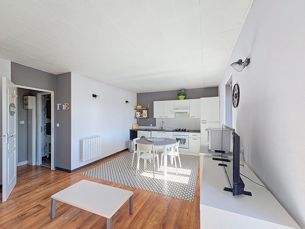 Vue du séjour lumineux et de l’espace repas de l’appartement Le Tilleul